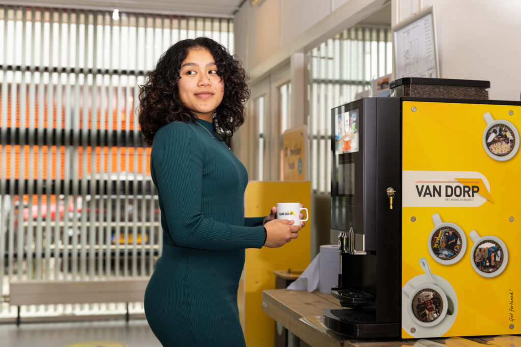 Medewerker pakt koffie bij een geel Van Dorp-koffieapparaat.