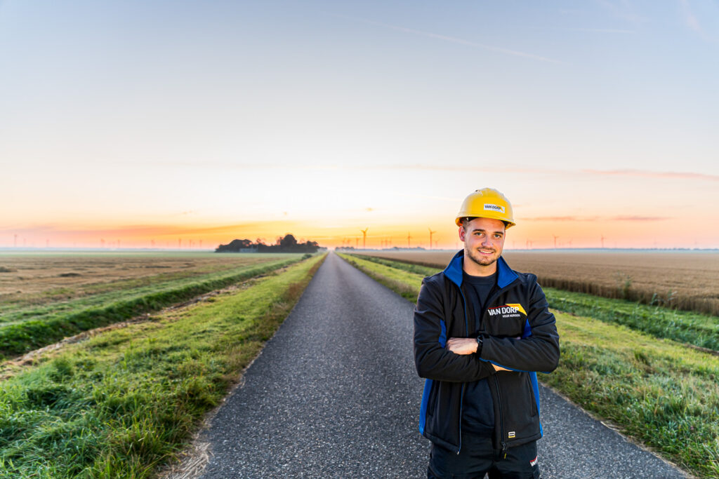 monteur in weiland met windmolens op de achtergrond