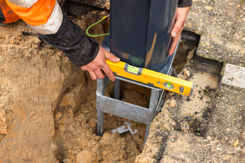 Monteur met waterpas bij een laadpaal